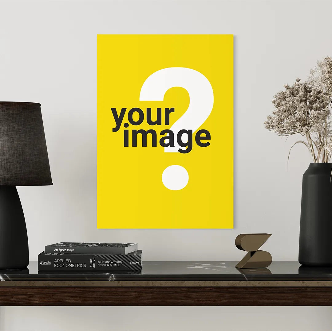 vertical wooden poster mockup with yellow background displayed on dark shelf styled with black table lamp books and decorative vase in modern interior setting